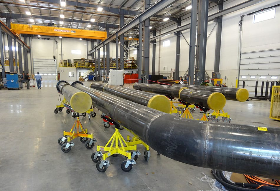Prepared industrial pipe sections arranged inside a fabrication workshop