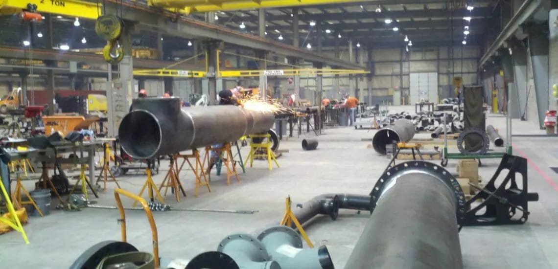 Pipe spool fabrication and welding inside an industrial workshop